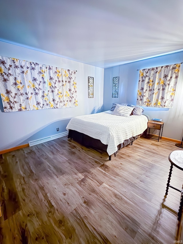 bedroom featuring wood finished floors and baseboards