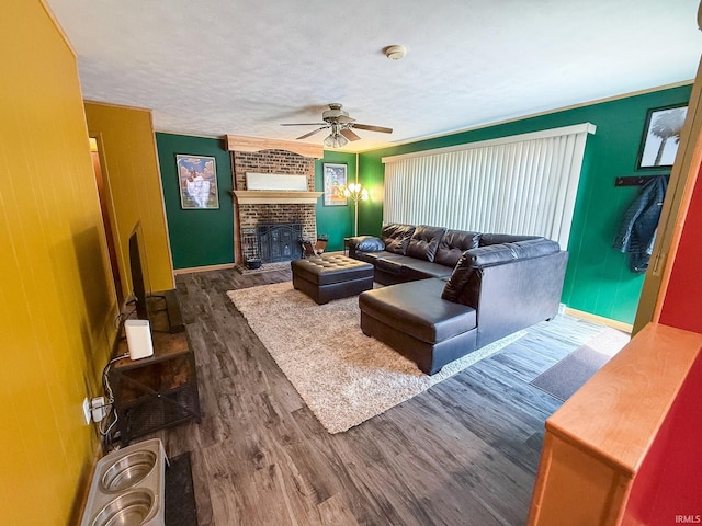 living room with wood finished floors, a ceiling fan, a fireplace, and baseboards