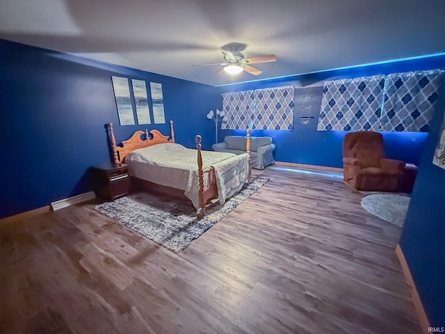 bedroom featuring wood finished floors, baseboards, and a ceiling fan