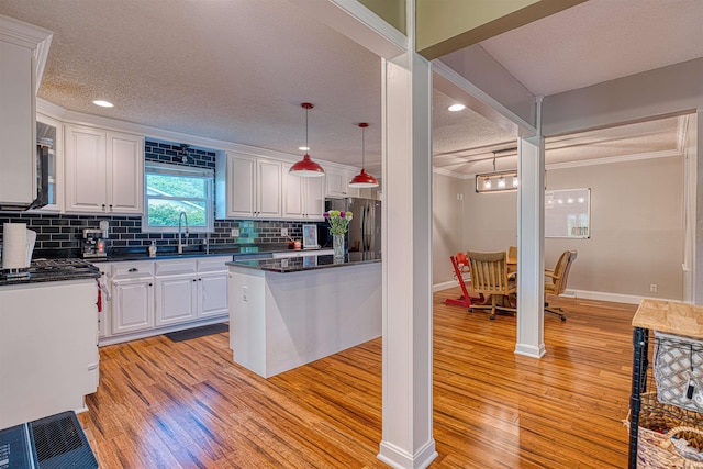 623 Forest Park Dr, Newburgh, IN 47630 - kitchen featuring freestanding refrigerator, crown molding, dark countertops, light wood-type flooring, and a textured ceiling