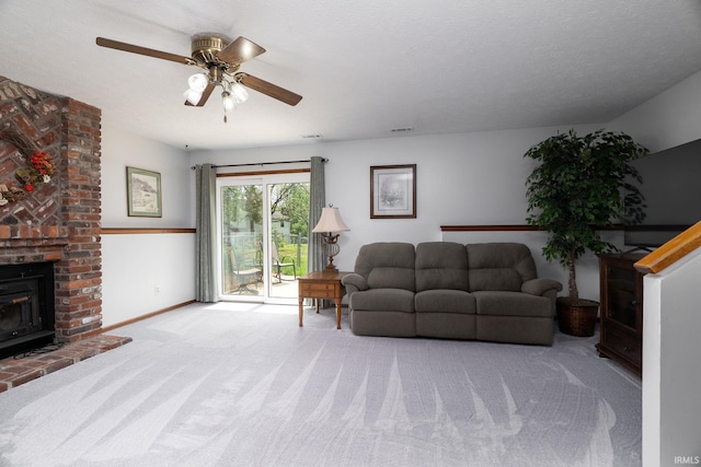 living room with carpet flooring, a ceiling fan, and a brick fireplace