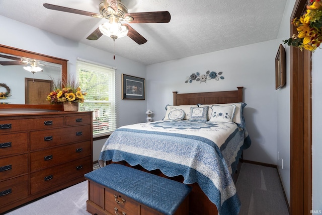 bedroom featuring light colored carpet, a ceiling fan, a textured ceiling, and baseboards