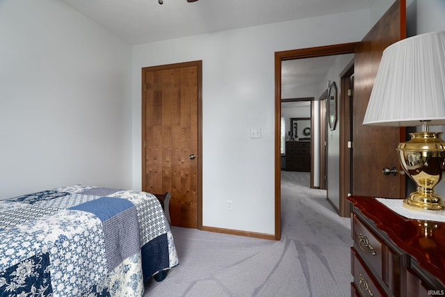 bedroom with light colored carpet and baseboards