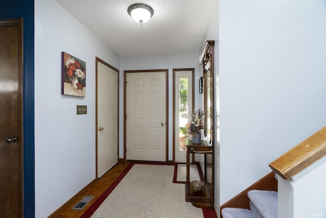 entryway with a textured ceiling and stairway