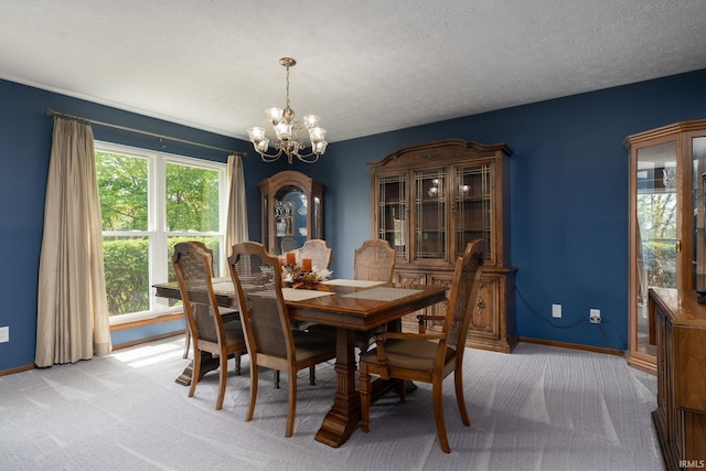 dining room featuring a chandelier, light carpet, baseboards, and a textured ceiling