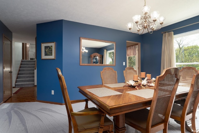 dining area featuring a chandelier, baseboards, and stairway