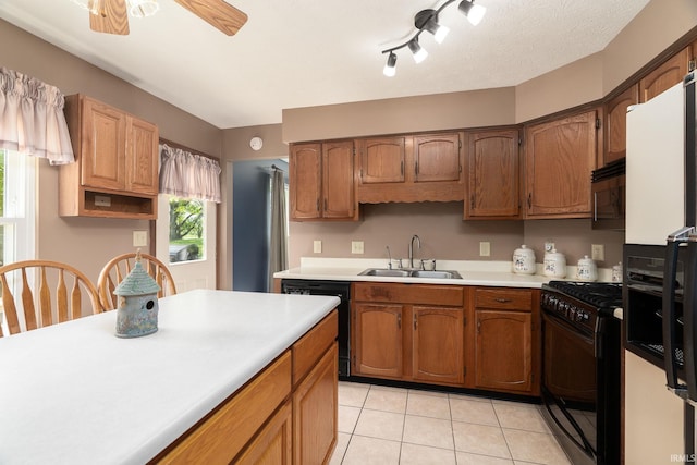 kitchen featuring a sink, black appliances, light countertops, light tile patterned floors, and ceiling fan