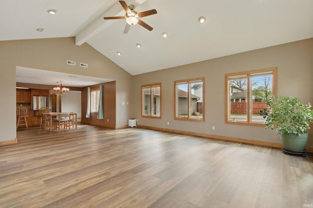 unfurnished living room with beam ceiling, a chandelier, ceiling fan, light wood-style floors, and high vaulted ceiling