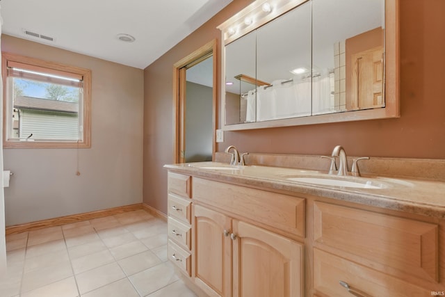 bathroom with double vanity, baseboards, and tile patterned flooring