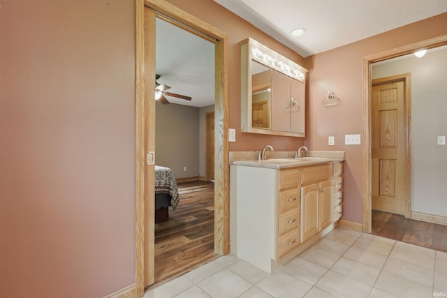 ensuite bathroom featuring ceiling fan, tile patterned floors, and baseboards