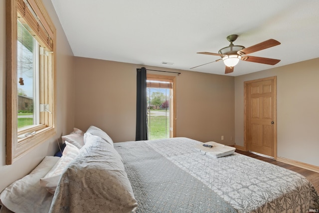 bedroom featuring wood finished floors, ceiling fan, baseboards, and access to outside