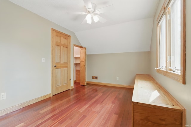 bonus room featuring wood finished floors, healthy amount of natural light, ceiling fan, vaulted ceiling, and baseboards