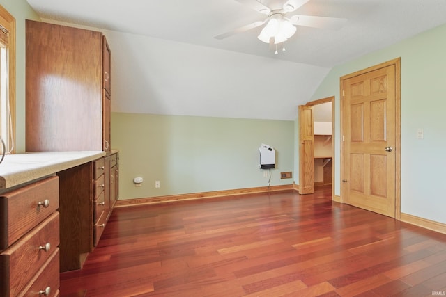 bonus room featuring vaulted ceiling, dark wood-type flooring, a ceiling fan, and baseboards