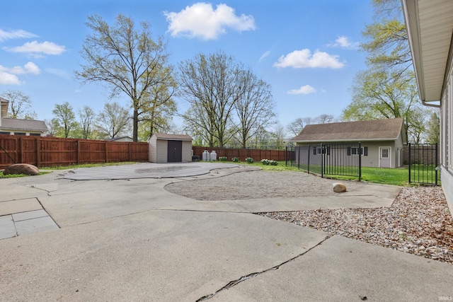 view of patio with an outdoor structure, a fenced backyard, and a shed
