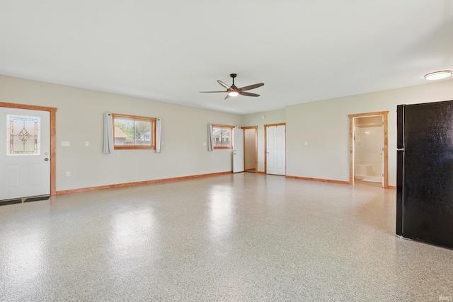 empty room with a ceiling fan and baseboards