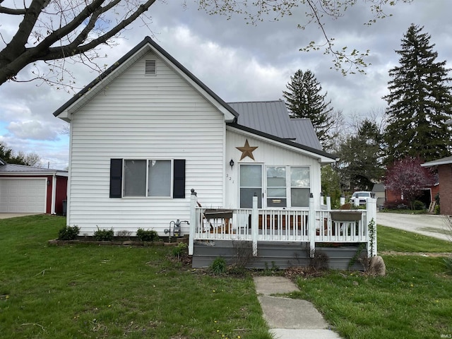 view of front of property with a front lawn, a detached garage, and an outdoor structure