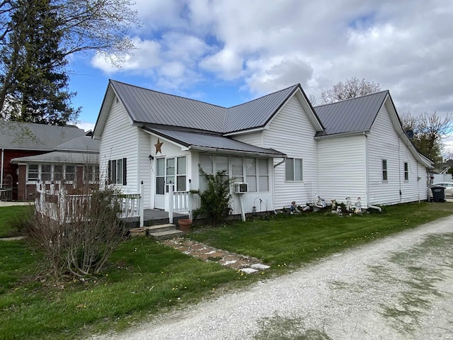 view of front of house with metal roof and a front lawn