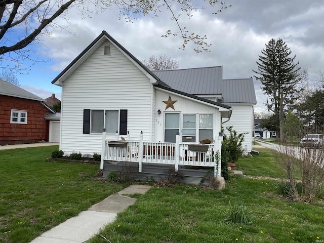 back of property with a lawn and metal roof