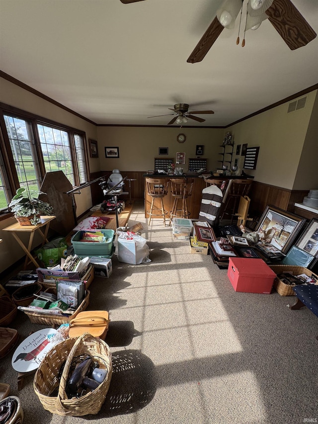 10059 Quince Rd, Plymouth, IN 46563 - living room with a wainscoted wall, carpet, a ceiling fan, crown molding, and wood walls