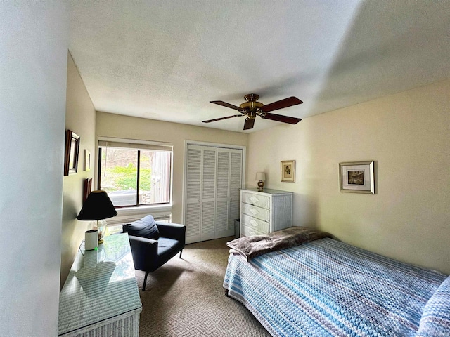 carpeted bedroom featuring a ceiling fan, a closet, and a textured ceiling