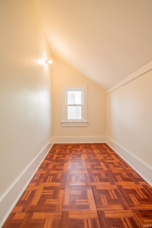 additional living space featuring lofted ceiling and baseboards