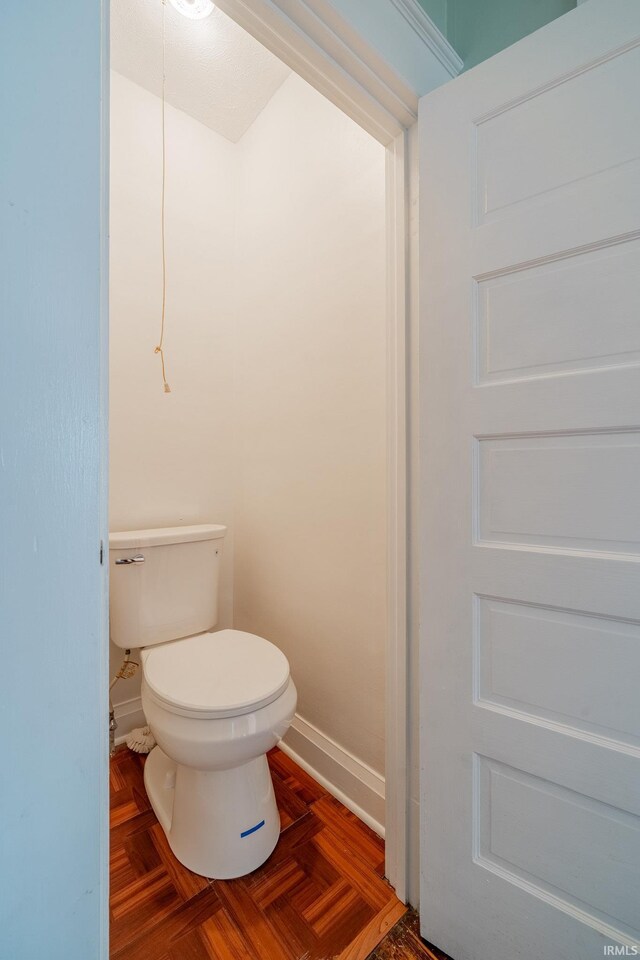 bathroom with toilet and baseboards