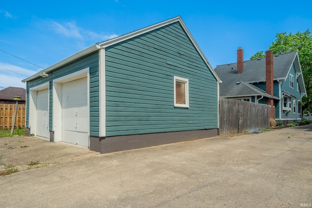 view of home's exterior with fence and a detached garage