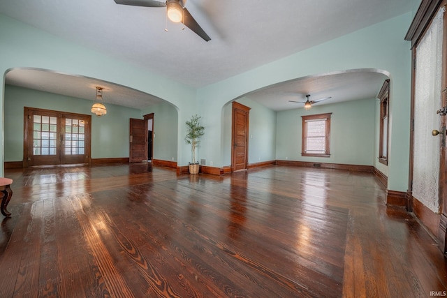 unfurnished living room featuring a ceiling fan, wood finished floors, and baseboards