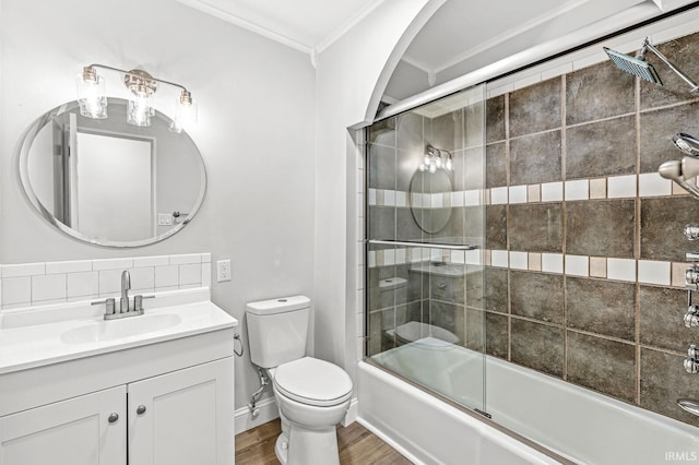 full bathroom with crown molding, wood finished floors, vanity, shower / bath combination with glass door, and toilet