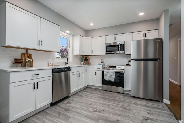 13840 Day Rd, Mishawaka, IN 46545 - kitchen featuring appliances with stainless steel finishes, white cabinetry, recessed lighting, backsplash, and light countertops