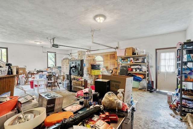 misc room featuring unfinished concrete flooring, a textured ceiling, and a garage