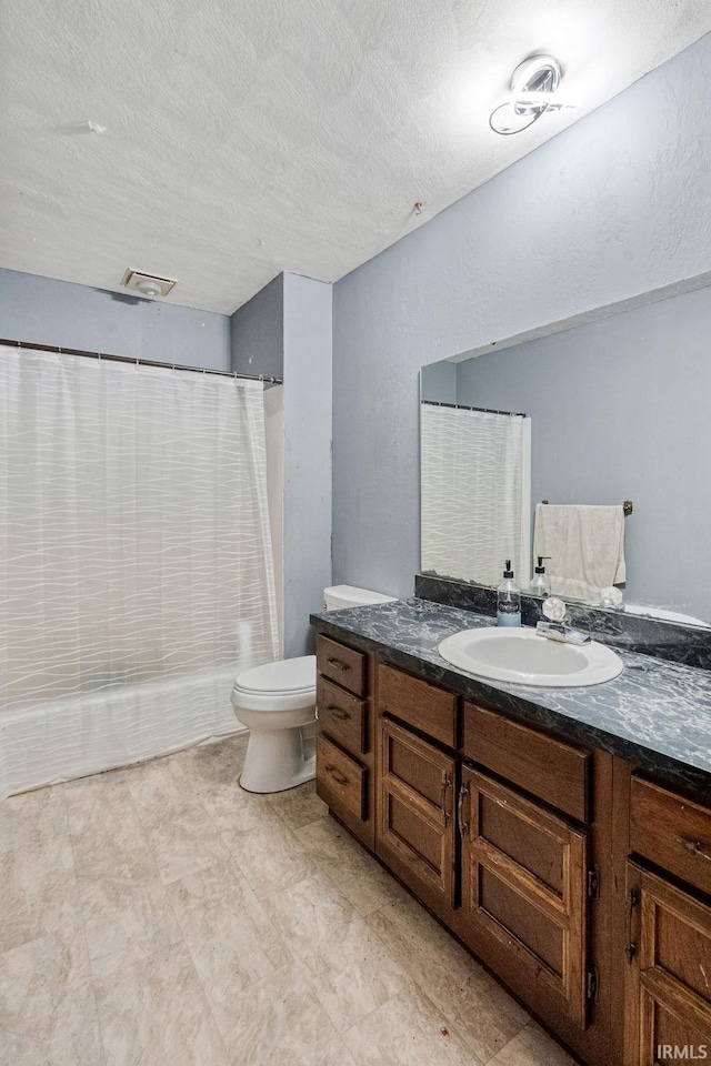 bathroom with vanity, toilet, and a textured ceiling