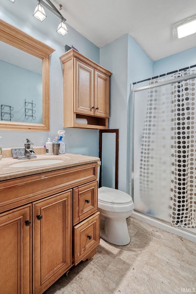 full bath with a shower stall, vanity, and toilet