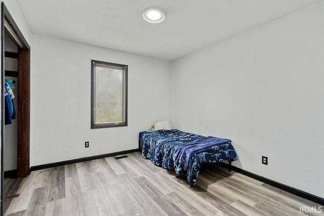 bedroom featuring wood finished floors and baseboards