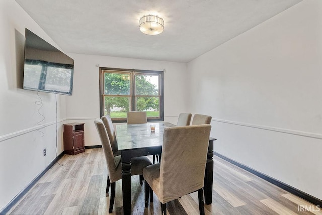dining space featuring light wood finished floors and baseboards