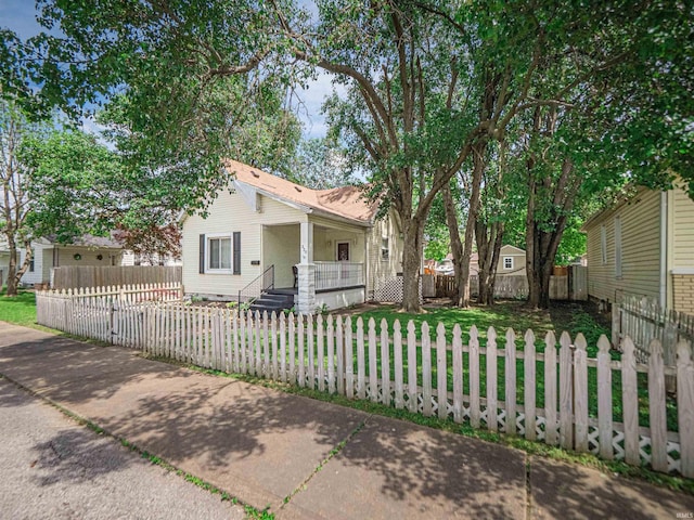 view of front of house with covered porch and a fenced front yard