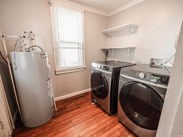 washroom featuring water heater, ornamental molding, wood finished floors, separate washer and dryer, and baseboards
