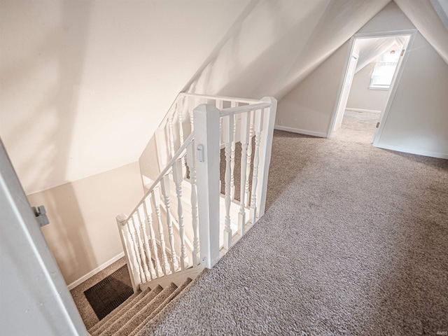 staircase with carpet flooring, lofted ceiling, and baseboards