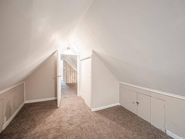 additional living space featuring lofted ceiling and carpet floors