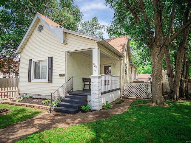 view of front of house featuring covered porch, brick siding, and crawl space