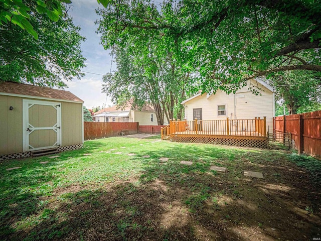 view of yard with a deck, a storage unit, and an outbuilding