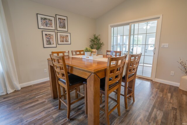 dining room with vaulted ceiling, dark wood-style flooring, and baseboards