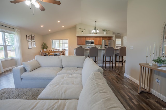 living room featuring baseboards, vaulted ceiling, plenty of natural light, dark wood-type flooring, and a ceiling fan