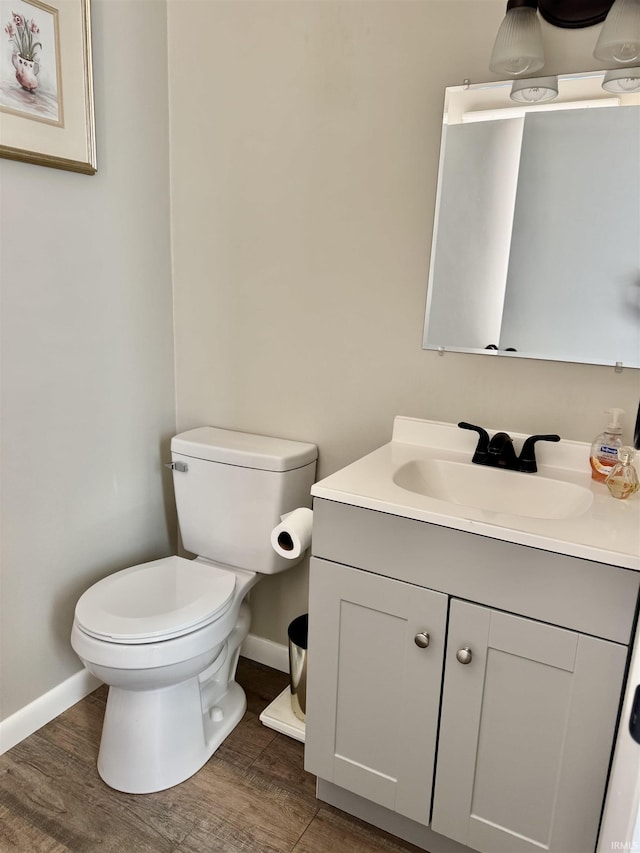 1719 Linwood Dr, Bedford, IN 47421 - half bathroom featuring baseboards, wood finished floors, vanity, and toilet