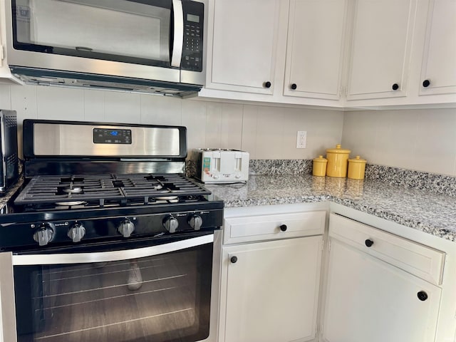 1719 Linwood Dr, Bedford, IN 47421 - kitchen with appliances with stainless steel finishes, white cabinets, decorative backsplash, and light stone counters