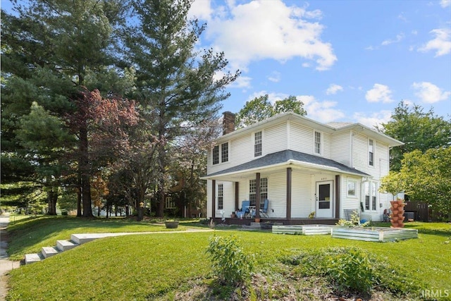 400 S Clay St, Frankfort, IN 46041 - view of front of home featuring a chimney, covered porch, a front yard, and a vegetable garden