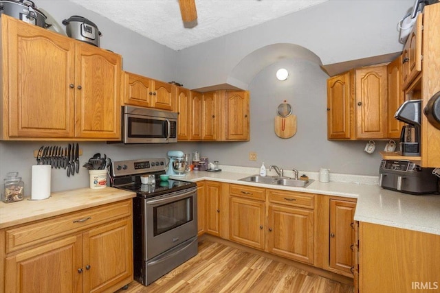 400 S Clay St, Frankfort, IN 46041 - kitchen featuring appliances with stainless steel finishes, a sink, light wood-style flooring, light countertops, and brown cabinetry
