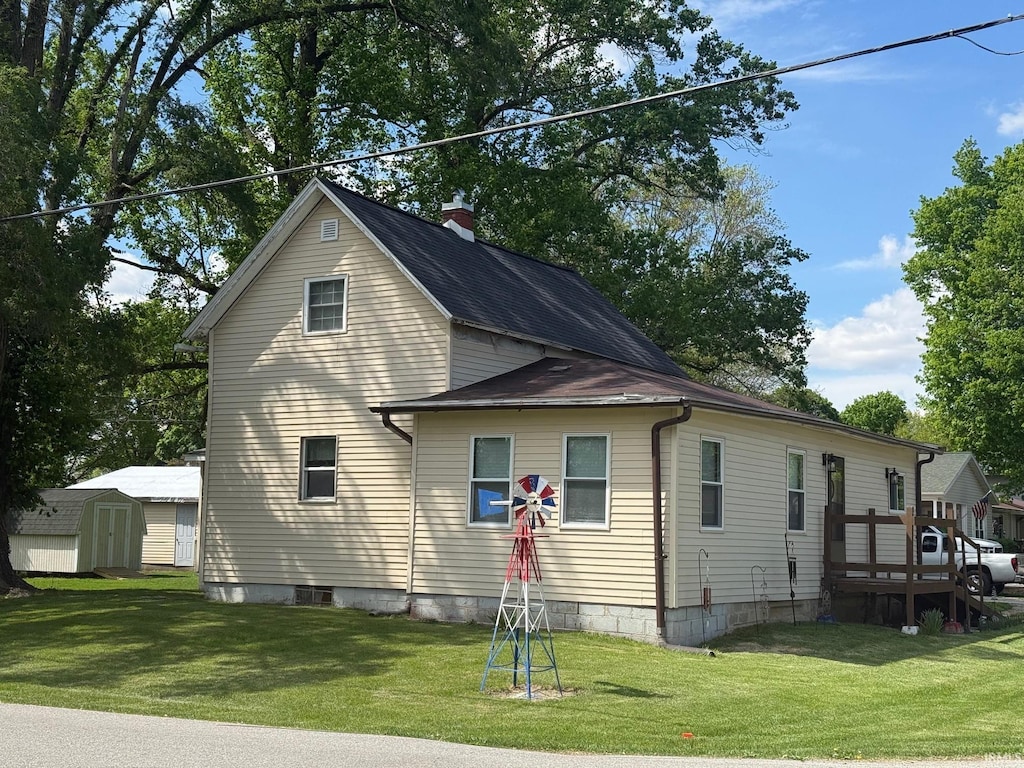 1124 S Hamilton St, Delphi, IN 46923 - view of home's exterior featuring a shed, a yard, an outbuilding, and a chimney