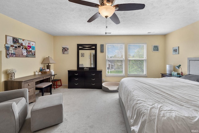 carpeted bedroom with a textured ceiling and a ceiling fan