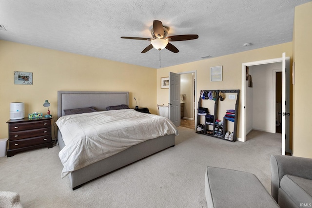 carpeted bedroom with a ceiling fan, a textured ceiling, and baseboards